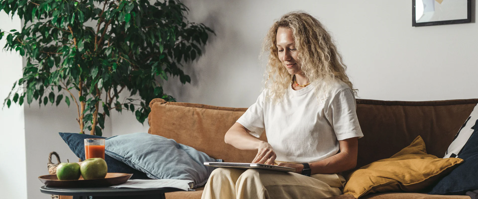 Frau mit Tablet auf dem Sofa in einem hellen Wohnzimmer