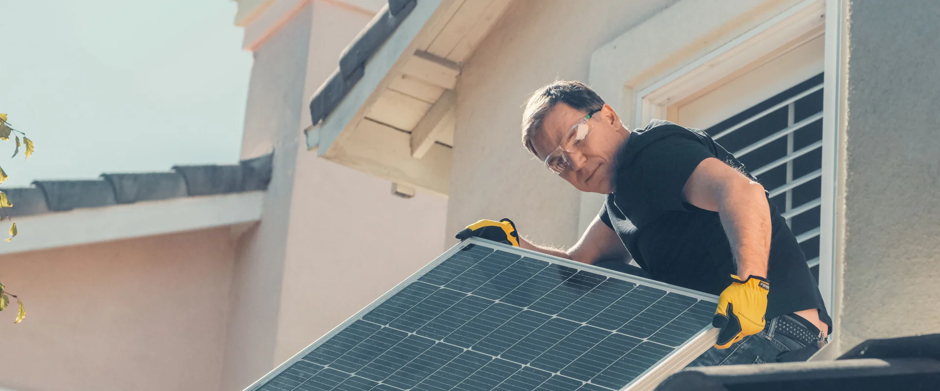 Monteur setzt ein Solarmodul auf ein Hausdach