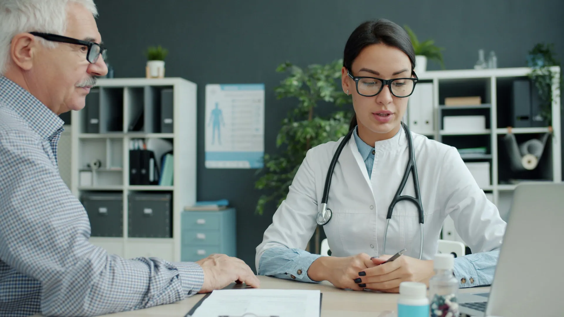 Ärztin im Beratungsgespräch mit einem Patienten im Sprechzimmer